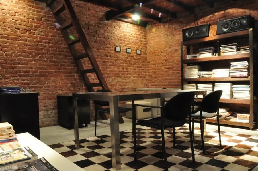 Invernón Arquitectos — Mesa de trabajo y biblioteca contra el muro existente